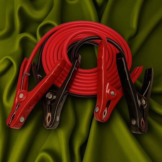 Red and black jumper cables on a green fabric background